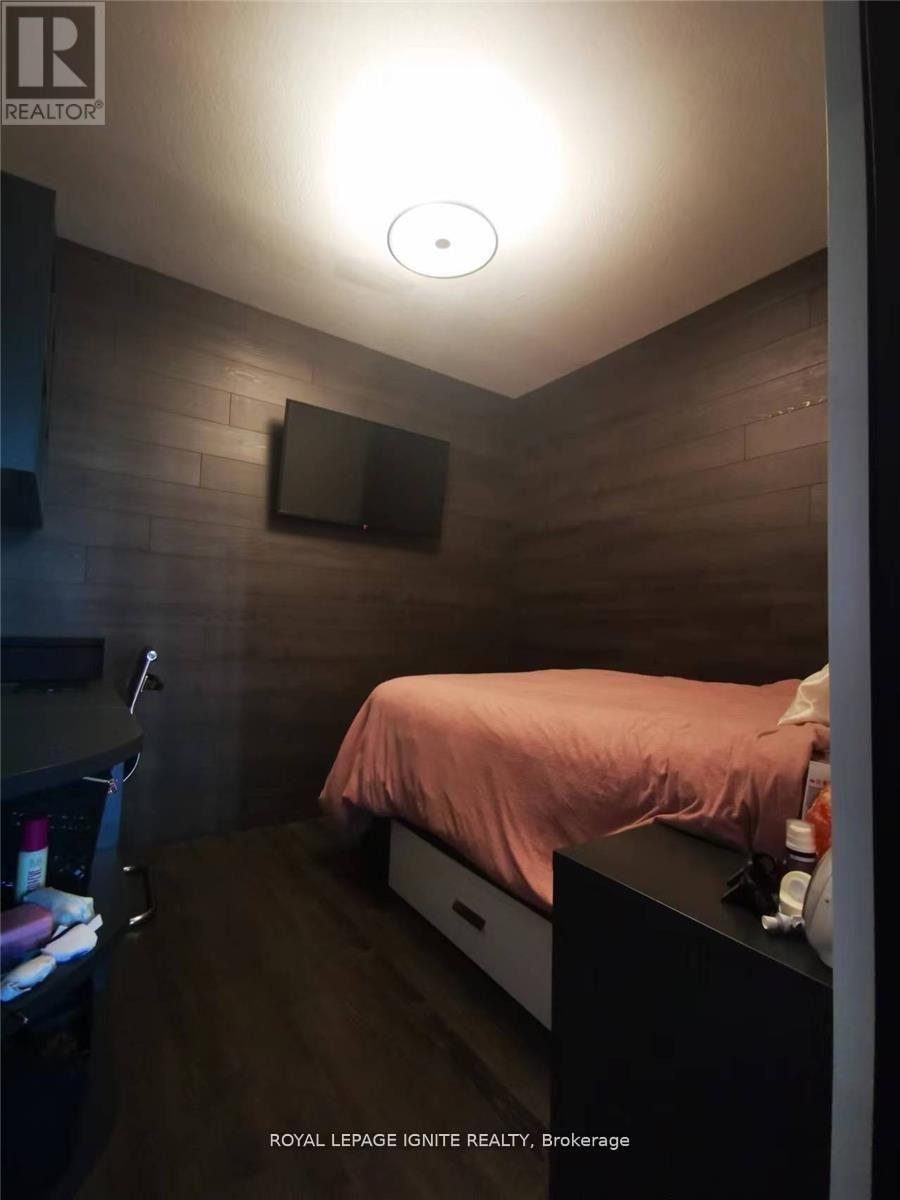 A bedroom with a bed, nightstand, and a mirror on the wall.