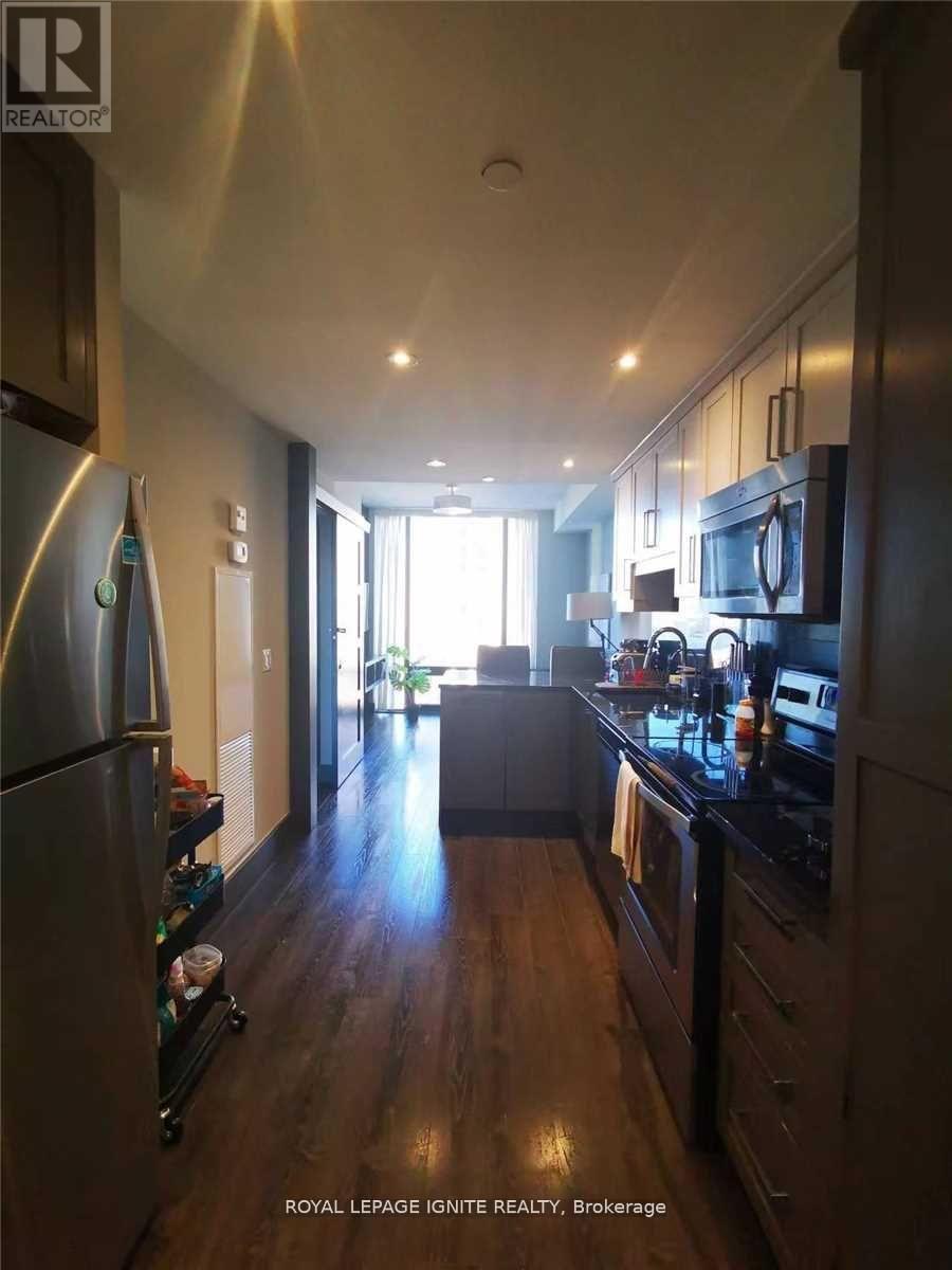 A kitchen with dark wood floors and modern appliances.