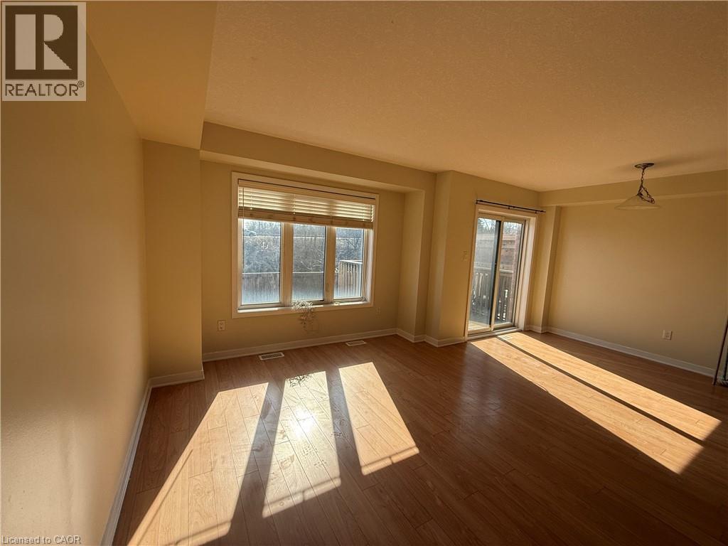 A sunny room with wooden floors and a large window.