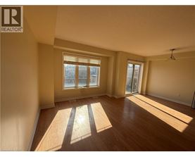 A sunny room with wooden floors and a large window.
