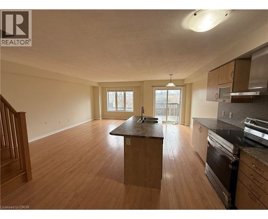 A kitchen with wooden floors and a large island in the middle.