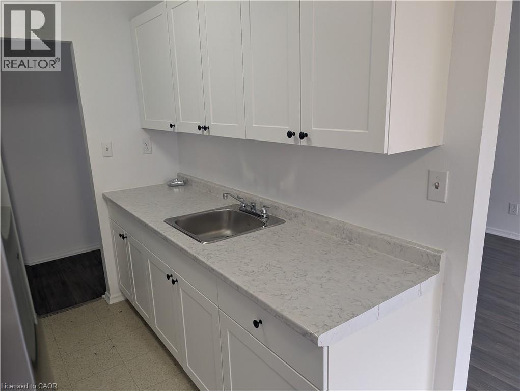 A kitchen with white cabinets and a marble countertop.