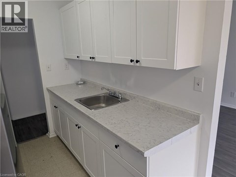 A kitchen with white cabinets and a marble countertop.