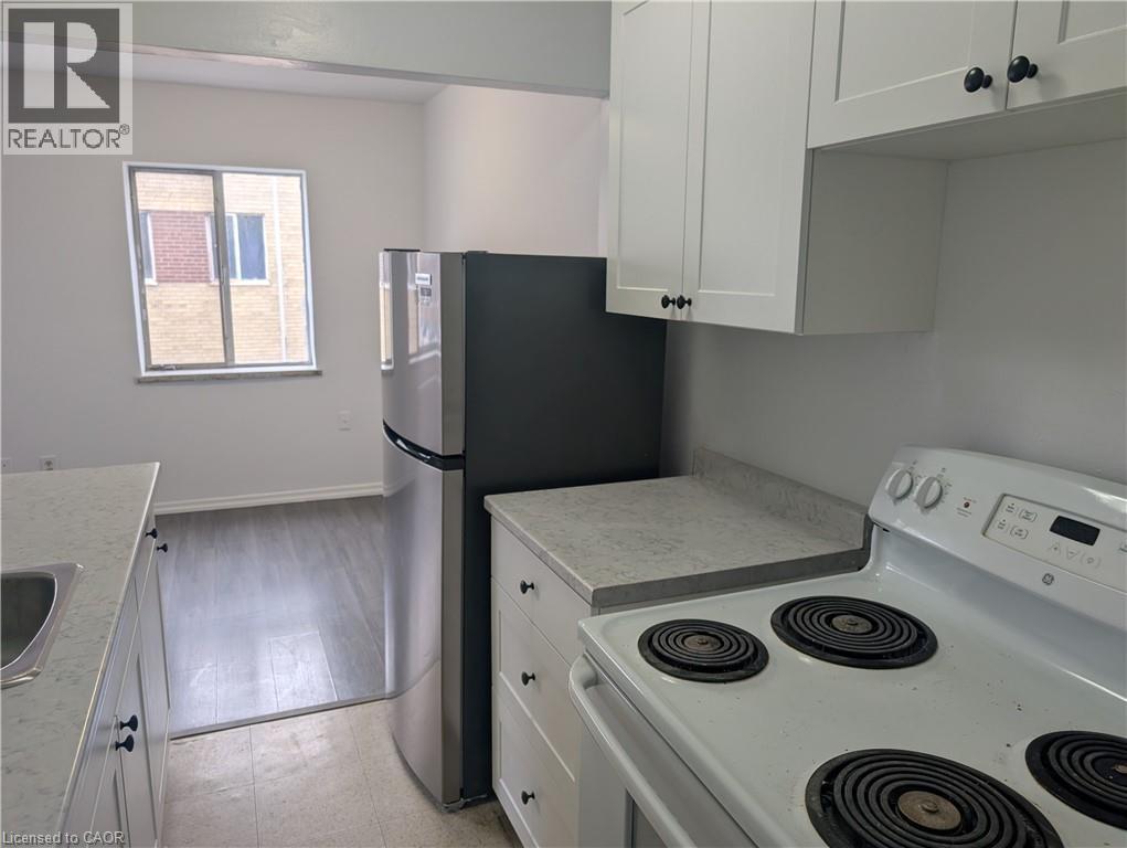 A kitchen with white cabinets and a white stove top oven.