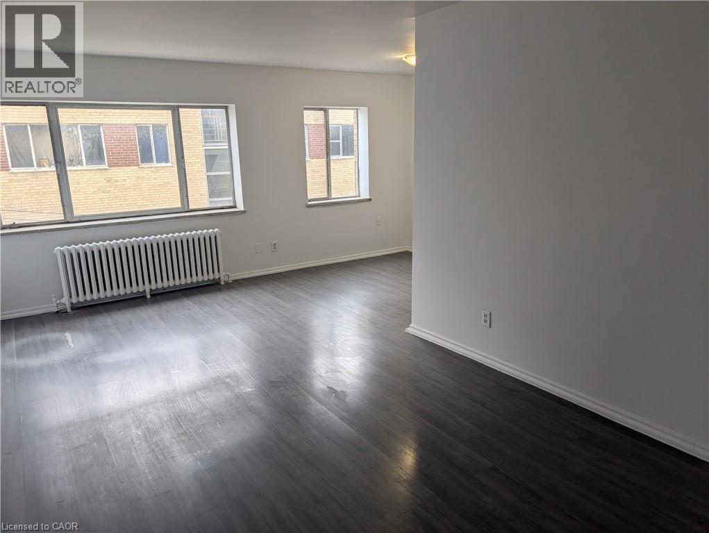 A spacious room with wooden floors and white walls.
