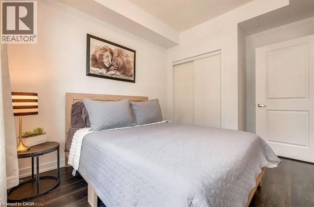 A bedroom with a large bed and a painting on the wall.