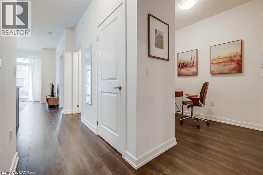 A hallway with a chair and a painting on the wall.