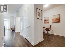 A hallway with a chair and a painting on the wall.