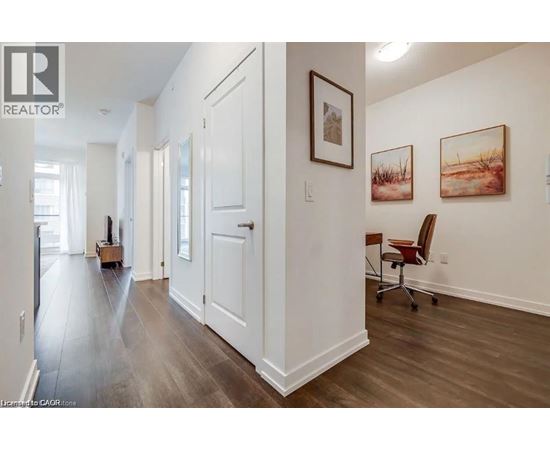 A hallway with a chair and a painting on the wall.