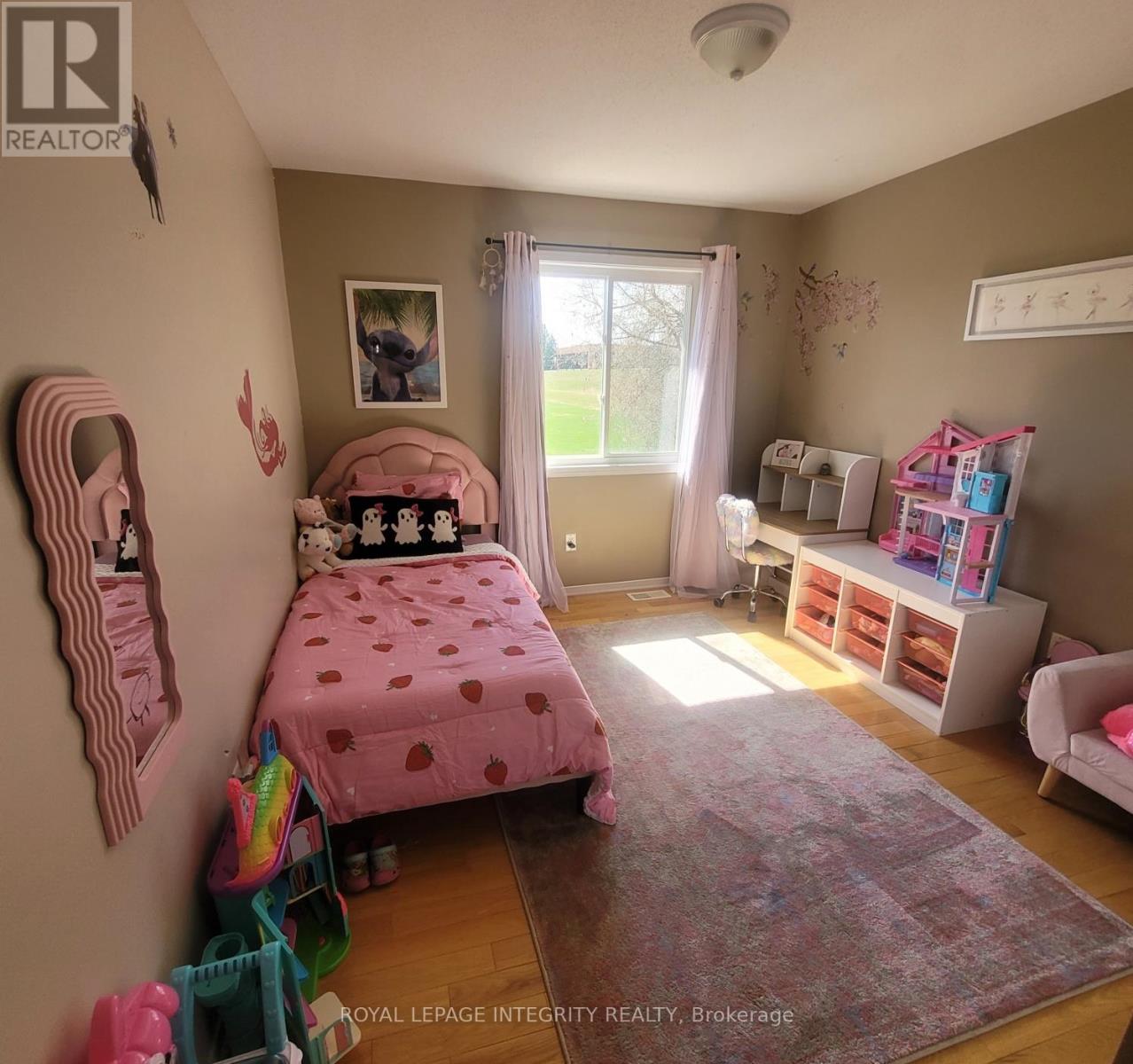 A child's bedroom with a pink bed and toys scattered on the floor.