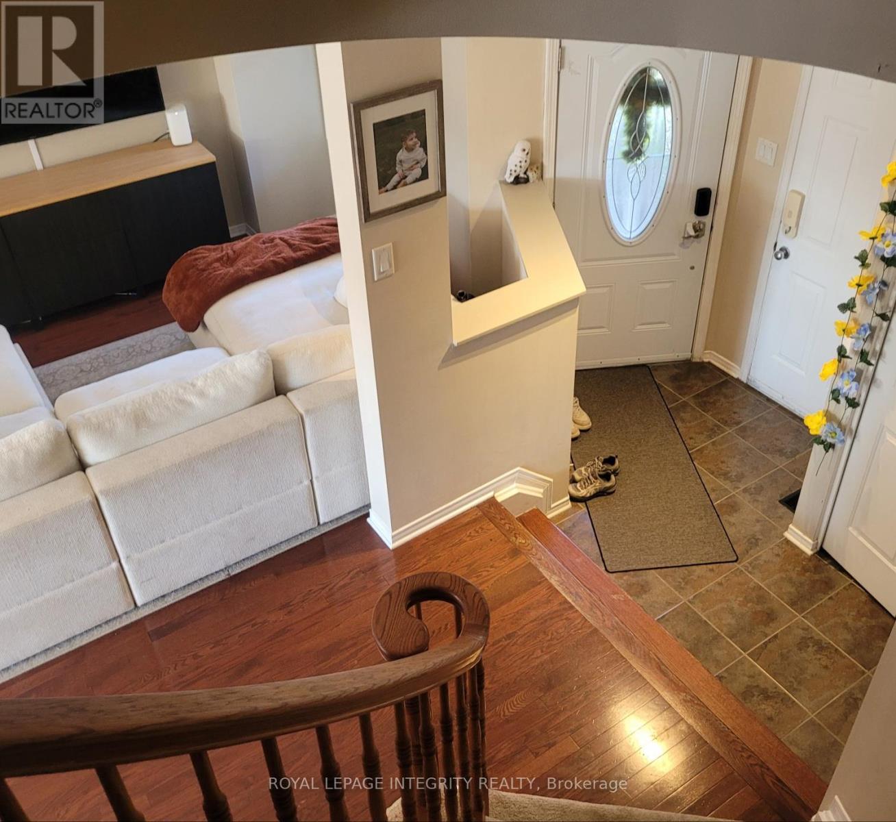 A living room with a couch and a painting on the wall.
