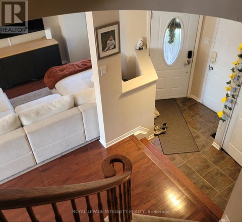 A living room with a couch and a painting on the wall.