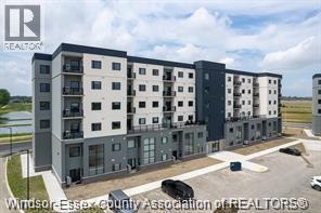 A modern apartment complex with a parking lot in front.