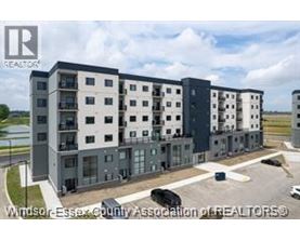 A modern apartment complex with a parking lot in front.