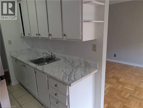A kitchen with white cabinets and a marble countertop.