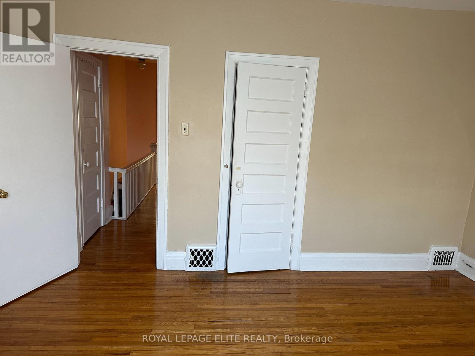 A room with a white door and a white wall.