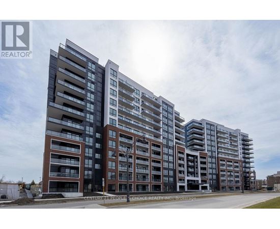 A large, modern apartment building with multiple balconies and a clear sky in the background.