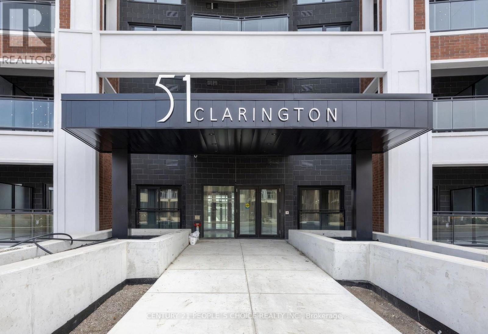 The entrance to a building named Clarington with a black and white sign.