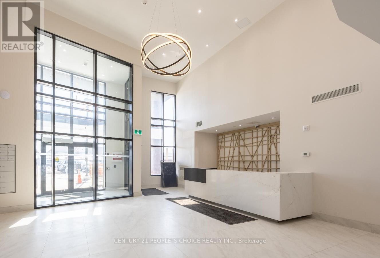 A reception area with a white marble counter and a large circular light fixture.