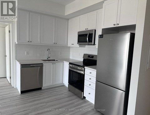 A kitchen with white cabinets and stainless steel appliances.