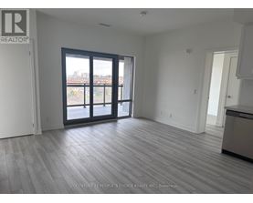 A spacious room with a view of the city through large windows.
