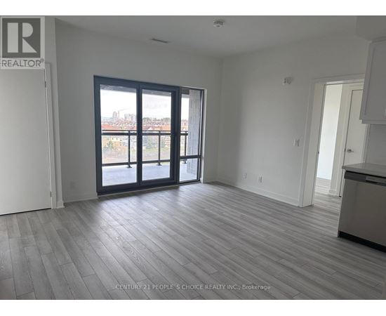 A spacious room with a view of the city through large windows.