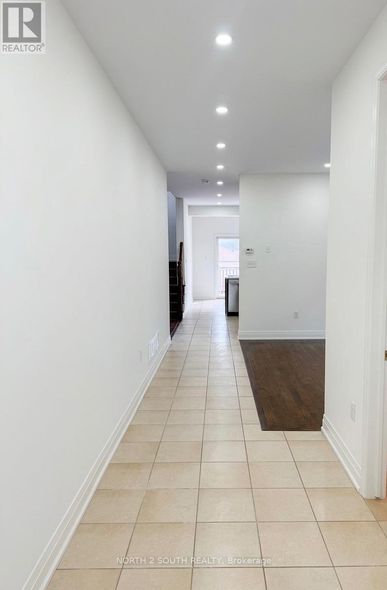 A long hallway with white walls and tiled flooring.