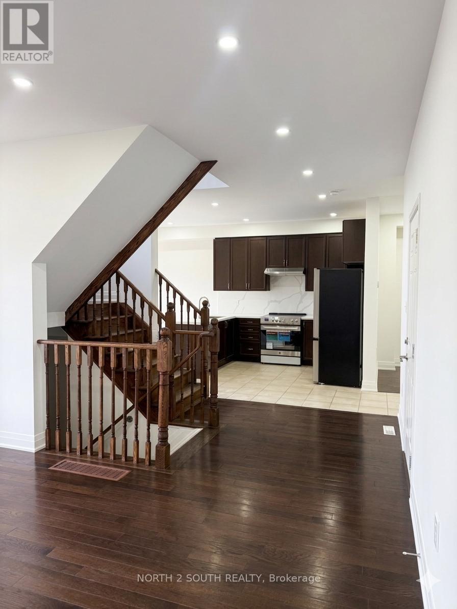 A wood staircase with a metal railing leads to a second floor.