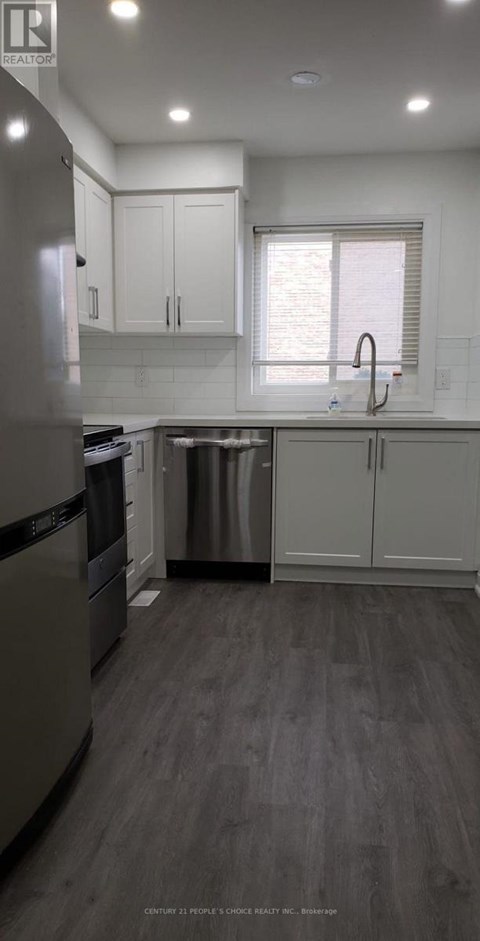 A modern kitchen with a dishwasher and a refrigerator.