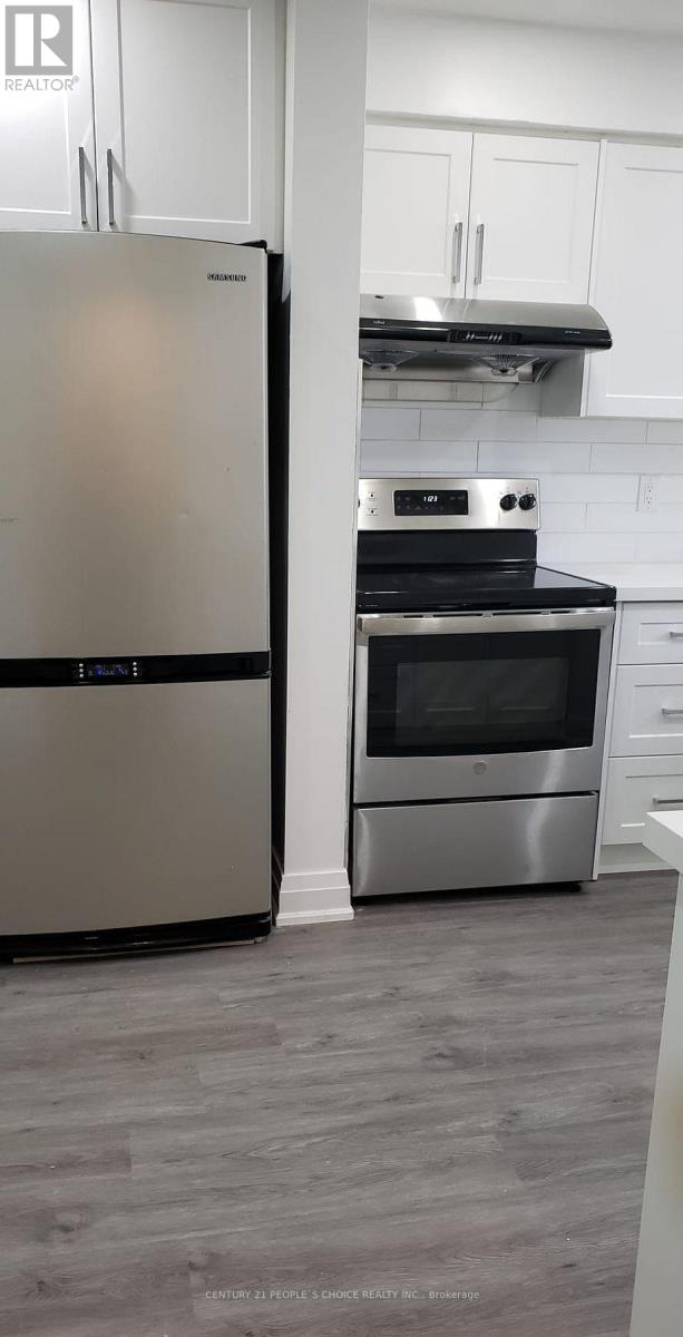 A modern kitchen with a stainless steel refrigerator and oven.