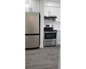 A modern kitchen with a stainless steel refrigerator and oven.