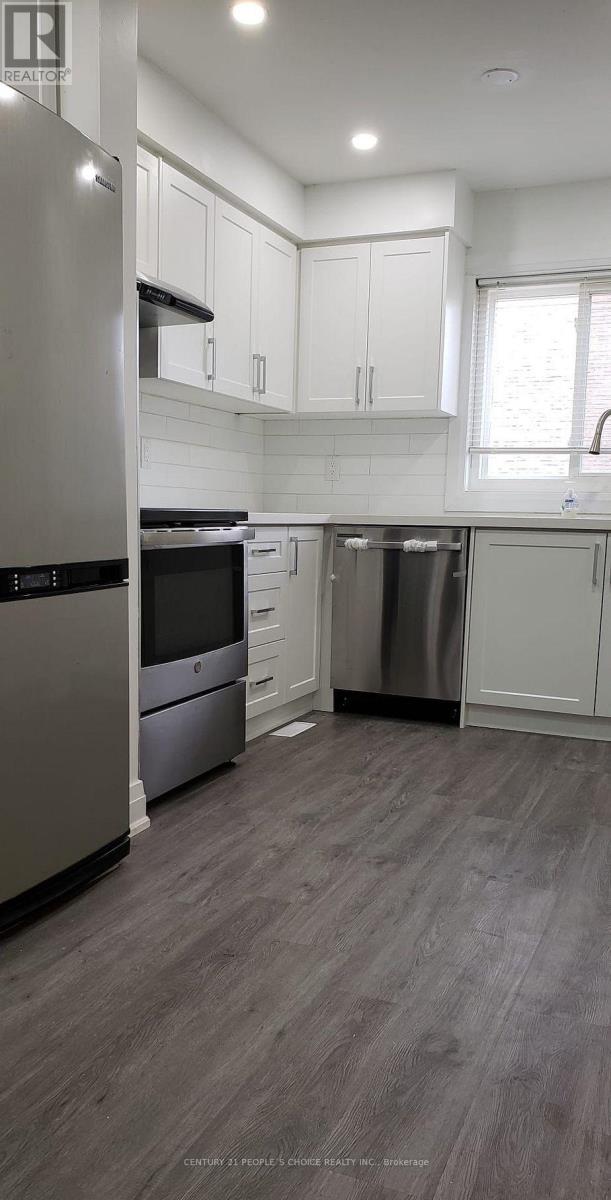 A modern kitchen with stainless steel appliances and white cabinetry.