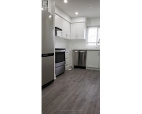 A modern kitchen with stainless steel appliances and white cabinetry.
