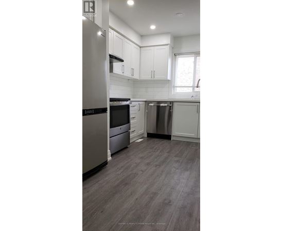 A modern kitchen with stainless steel appliances and white cabinetry.