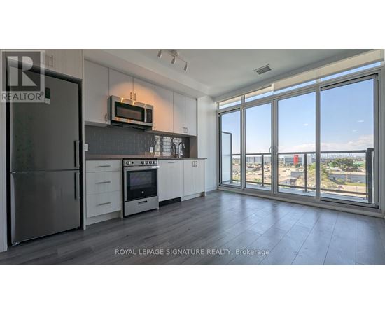 A kitchen with a refrigerator, oven, and microwave.