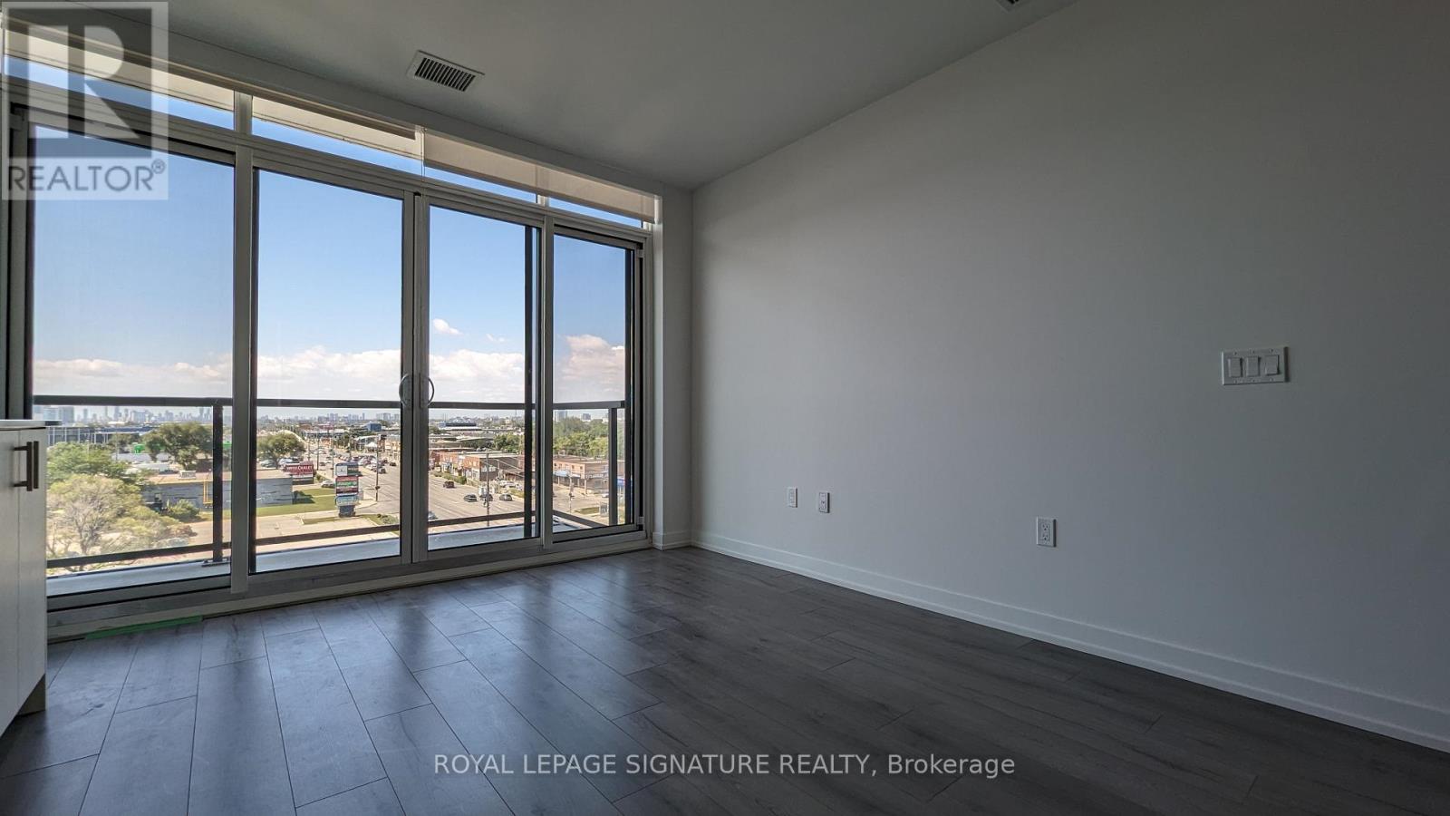 A room with a large window overlooking a cityscape.