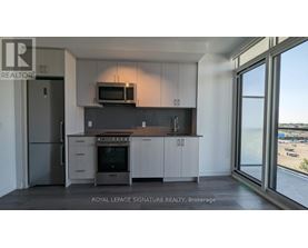 A kitchen with a refrigerator, oven, microwave, and cabinets.