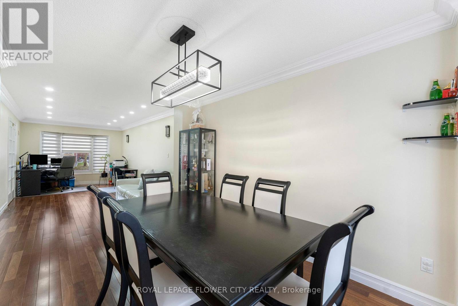 A dining room with a black table and chairs.