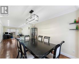 A dining room with a black table and chairs.