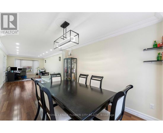 A dining room with a black table and chairs.