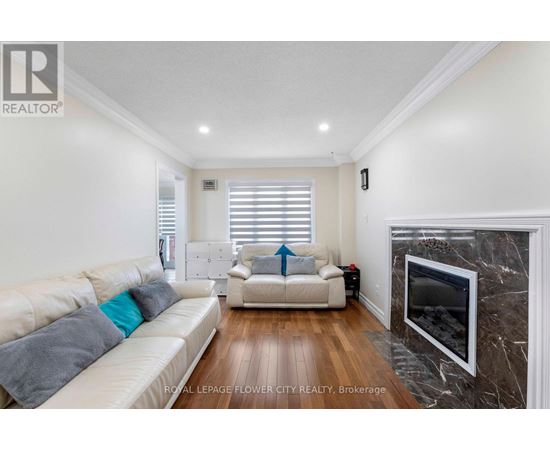 A living room with a white couch and a fireplace.