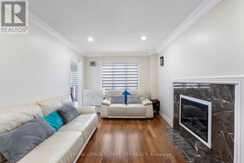 A living room with a white couch and a fireplace.