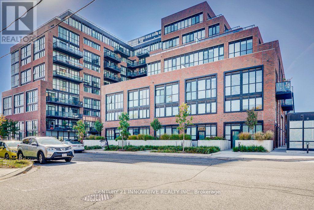 A modern multi-story building with a parking lot in front.
