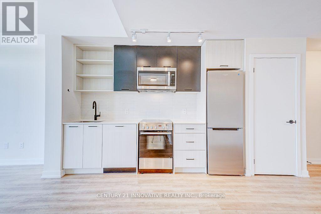 A kitchen with white cabinets and a stainless steel refrigerator.