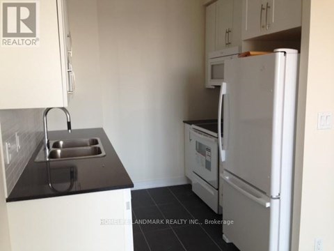 A small kitchen with a sink and a refrigerator.
