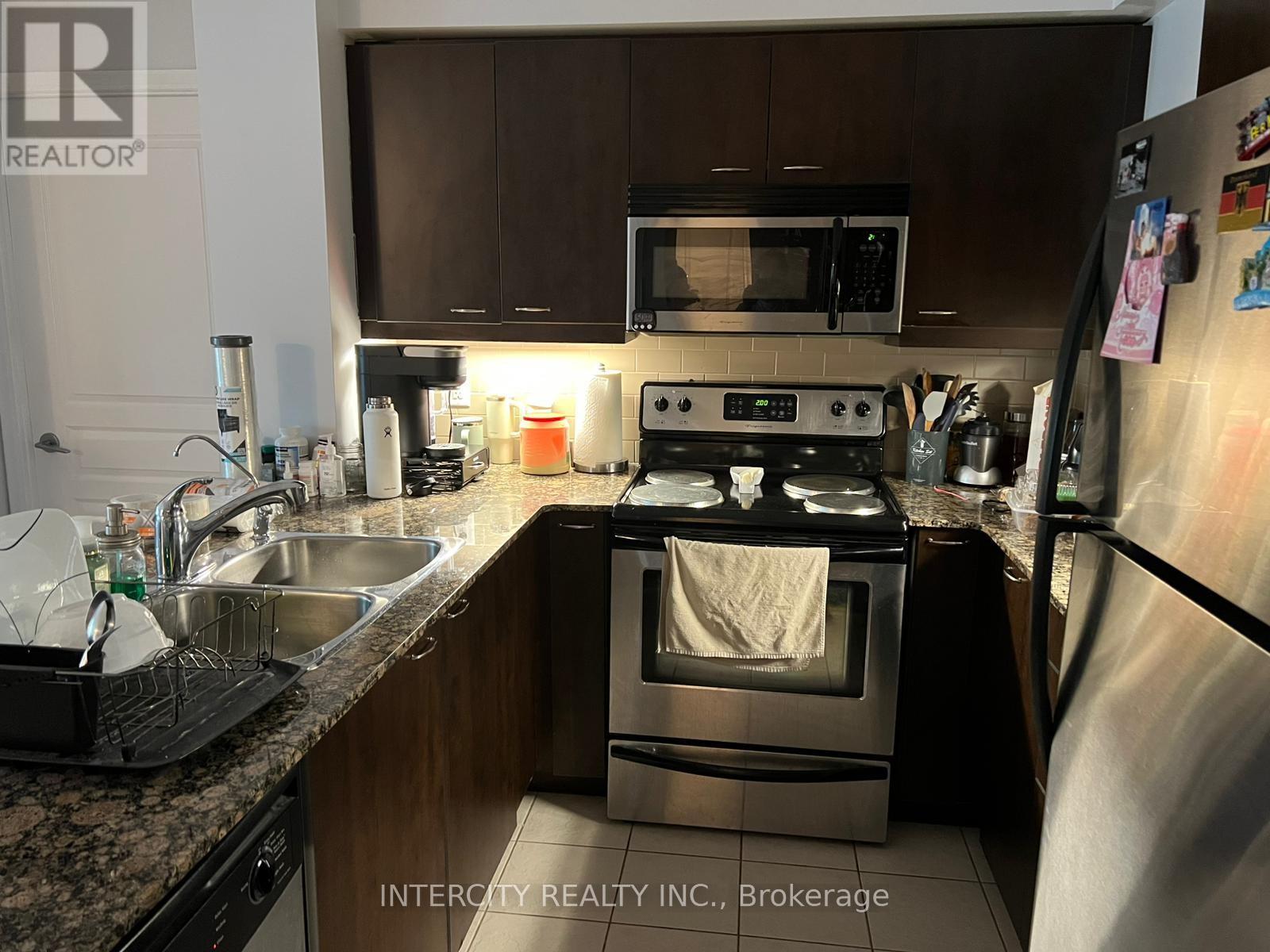 A kitchen with a stove, microwave, and refrigerator.