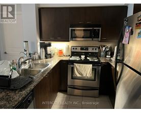 A kitchen with a stove, microwave, and refrigerator.