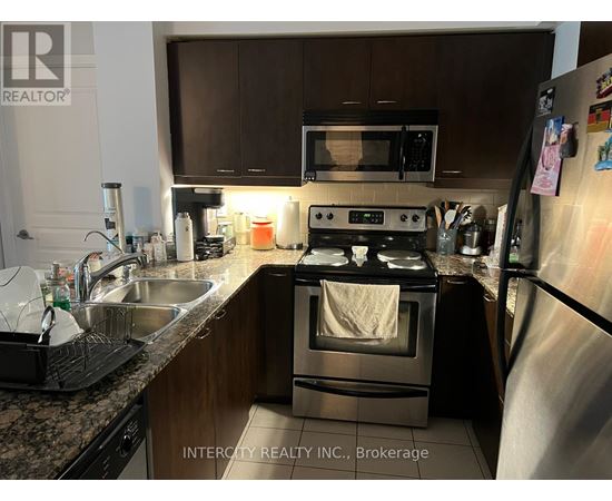A kitchen with a stove, microwave, and refrigerator.