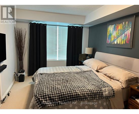 A bedroom with a bed, nightstand, and a painting on the wall.