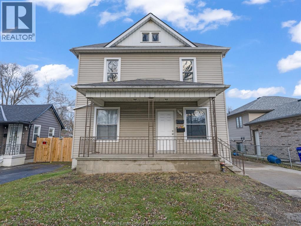 A two-story house with a front porch is for sale.